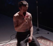 Watch Matty Healy pause The 1975 show to eat raw steak, do push-ups and crawl into a TV